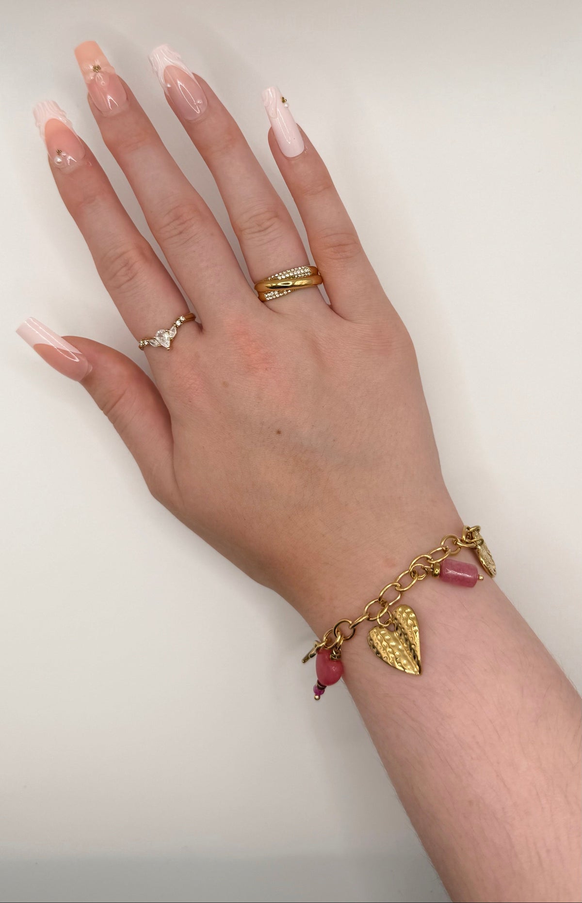 Bracelet à charms Elyne, doré, en acier inoxydable, orné d’une lune dorée, de cœurs gravés, d’un cœur rose et de délicates pierres roses