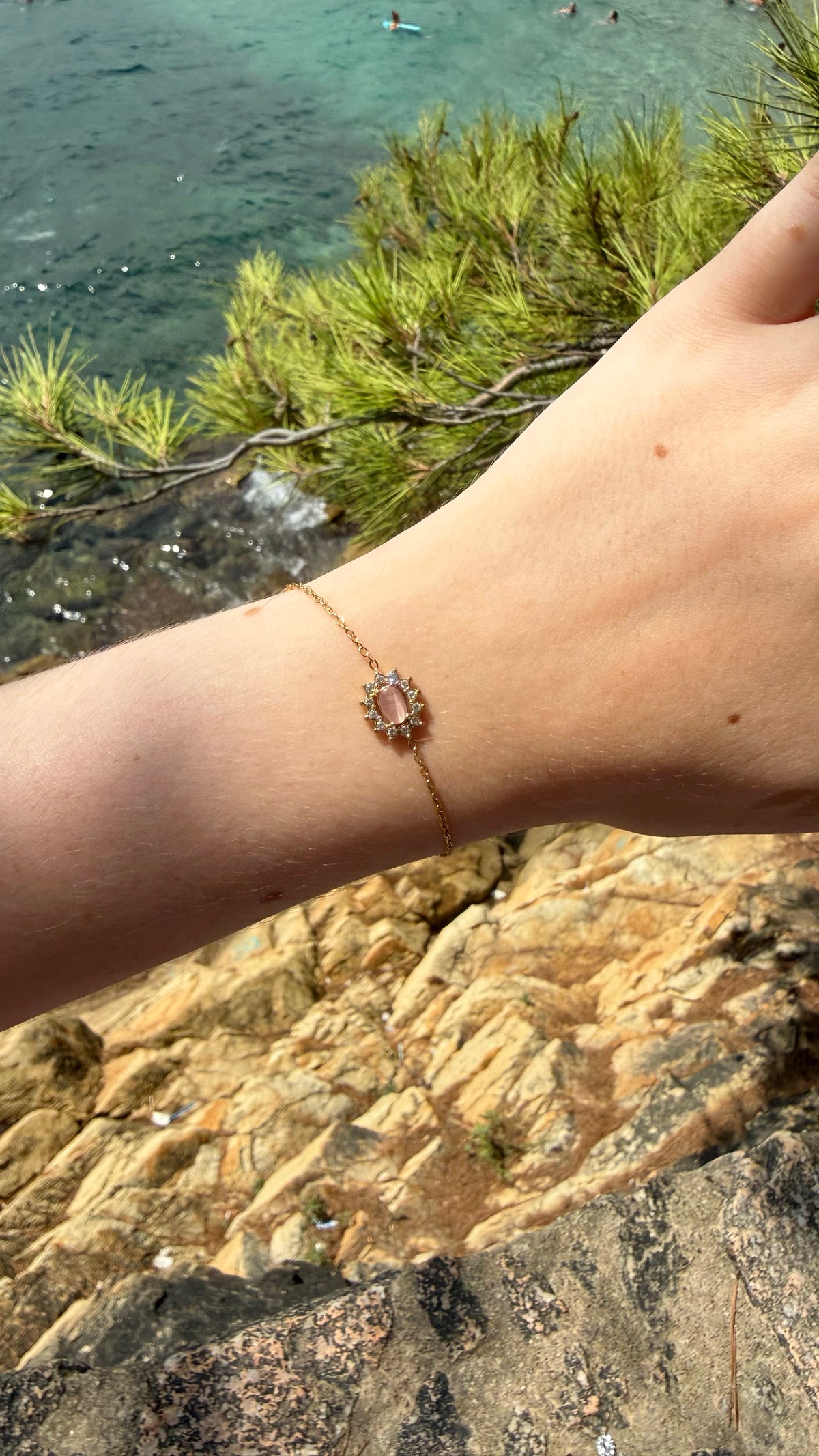 Bracelet Roxane, doré, en acier inoxydable, orné d’une pierre ovale rose entourée de strass scintillants