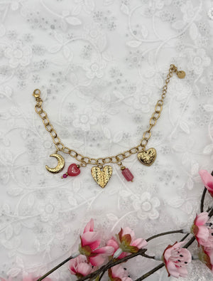 Bracelet à charms Elyne, doré, en acier inoxydable, orné d’une lune dorée, de cœurs gravés, d’un cœur rose et de délicates pierres roses