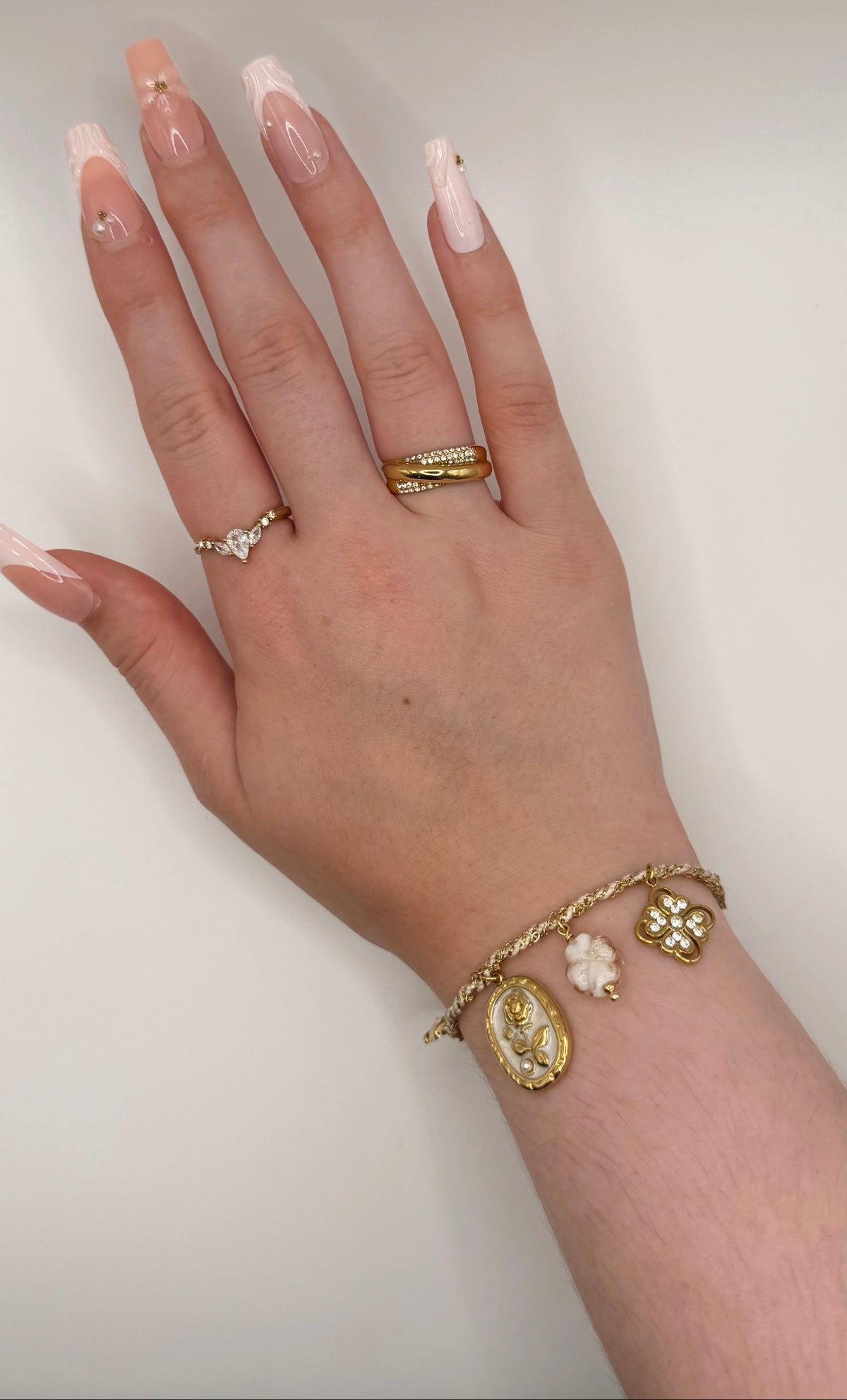 Bracelet Opalys, doré, en acier inoxydable, orné de fleurs dorées, d’un trèfle blanc, de charms floraux roses et d’une perle